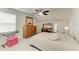 Bedroom with ceiling fan, wooden dresser, desk and chair, and a comfortable bed with side tables at 10708 52Nd E Ct, Parrish, FL 34219