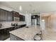 Modern kitchen features stainless steel appliances, dark wood cabinetry, and granite countertops with a large center island at 10708 52Nd E Ct, Parrish, FL 34219