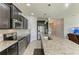 Modern kitchen with dark wood cabinetry, stainless steel appliances, a large island, and views of the living area at 10708 52Nd E Ct, Parrish, FL 34219
