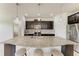 Bright kitchen features a large granite island, stainless steel appliances, and dark wood cabinetry at 10708 52Nd E Ct, Parrish, FL 34219