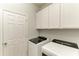 Laundry room with white cabinets, a door, and modern washer and dryer units at 10708 52Nd E Ct, Parrish, FL 34219