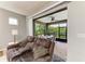 Living room area featuring a brown leather sofa and open sliding door to an outdoor patio at 10708 52Nd E Ct, Parrish, FL 34219