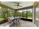 Covered screened patio features an outdoor dining area, ceiling fan, and view of the landscaped backyard at 10708 52Nd E Ct, Parrish, FL 34219