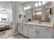 Well-lit bathroom with double sinks, a large mirror, and a seamless transition to the shower area and adjacent bedroom at 10724 Spring Tide Way, Parrish, FL 34219