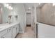 Modern bathroom featuring double sinks, a well-lit vanity, and a view into the walk-in shower and closet space at 10724 Spring Tide Way, Parrish, FL 34219