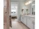 Spacious bathroom featuring a dual sink vanity, a step-in shower, and a view into the bedroom, blending comfort and convenience at 10724 Spring Tide Way, Parrish, FL 34219