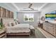 Stylish bedroom featuring a queen bed, matching nightstands, a ceiling fan and a large window with a view to the outside at 10724 Spring Tide Way, Parrish, FL 34219