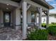 Welcoming front porch with brick pavers, comfortable seating, and manicured landscaping at 10724 Spring Tide Way, Parrish, FL 34219