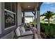 Inviting front porch with comfortable seating, a landscaped garden and elegant structural columns at 10724 Spring Tide Way, Parrish, FL 34219