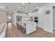 Bright, modern kitchen with stainless steel appliances, large island with seating, and wood-look flooring at 10724 Spring Tide Way, Parrish, FL 34219
