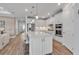 Contemporary kitchen with white cabinetry, stainless steel appliances, large island with seating and hardwood floors at 10724 Spring Tide Way, Parrish, FL 34219