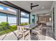 Comfortable lanai with a dining set overlooking the backyard and lake, plus a glimpse into the stylish living room at 10724 Spring Tide Way, Parrish, FL 34219