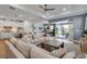 Bright living room open to the kitchen, featuring hardwood floors, comfortable seating, and seamless lanai access at 10724 Spring Tide Way, Parrish, FL 34219