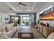 Stylish living room with hardwood floors, large windows, and seamless transition to the outdoor patio and backyard at 10724 Spring Tide Way, Parrish, FL 34219