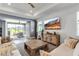Comfortable living room featuring large TV, neutral tones, and seamless access to an outdoor patio space at 10724 Spring Tide Way, Parrish, FL 34219