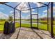 Screened-in patio featuring brick pavers, a grill, and stunning views of the lake and neighborhood at 10724 Spring Tide Way, Parrish, FL 34219