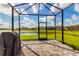 Screened-in patio featuring brick pavers, a grill, and stunning views of the lake and neighborhood at 10724 Spring Tide Way, Parrish, FL 34219