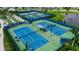 View of the community tennis courts surrounded by lush landscaping and a pond at 10724 Spring Tide Way, Parrish, FL 34219