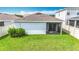 Green backyard with a white house and screened in patio at 11015 High Noon Trl, Parrish, FL 34219