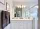 Modern bathroom featuring double sinks, a large mirror, stylish lighting, and a glass-enclosed shower at 11015 High Noon Trl, Parrish, FL 34219