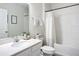 Well-lit bathroom featuring a white vanity, framed mirror, and shower with a white curtain at 11015 High Noon Trl, Parrish, FL 34219