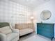 Charming Bedroom featuring a crib, dresser, and comfortable chair, designed with a neutral color palette at 11015 High Noon Trl, Parrish, FL 34219