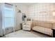 Cozy Bedroom with a crib, plush chair, and stylish decor, creating a warm and inviting space for a baby at 11015 High Noon Trl, Parrish, FL 34219