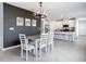 Bright dining room with modern lighting and a gray accent wall is adjacent to the kitchen at 11015 High Noon Trl, Parrish, FL 34219