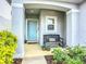Inviting front porch with bench, flower pots, and view of an attractive, light blue front door at 11015 High Noon Trl, Parrish, FL 34219