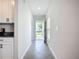 Bright hallway with neutral walls leading to the front door and offering a view of the kitchen at 11015 High Noon Trl, Parrish, FL 34219