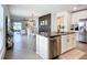 Bright kitchen with stainless steel appliances and an island with granite countertops overlooks living and dining areas at 11015 High Noon Trl, Parrish, FL 34219