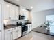 Stylish kitchen showcasing stainless steel appliances, granite countertops, and sleek white cabinetry at 11015 High Noon Trl, Parrish, FL 34219