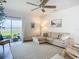 Light-filled living room with sliding glass doors to the backyard and neutral-colored furniture at 11015 High Noon Trl, Parrish, FL 34219
