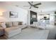 Bright living room overlooks the kitchen and dining areas with neutral furniture and a ceiling fan at 11015 High Noon Trl, Parrish, FL 34219