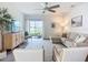 Living room with a ceiling fan, sliding glass doors to the patio, and neutral-toned furniture at 11015 High Noon Trl, Parrish, FL 34219