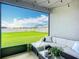 Screened-in patio with comfortable seating and a view of the green backyard at 11015 High Noon Trl, Parrish, FL 34219
