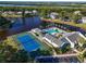 Aerial shot of community center with a tennis court, swimming pool, and clubhouse near the water at 11367 Perico Isle Cir, Bradenton, FL 34209