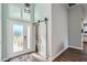 Bright foyer with a frosted glass front door, sliding barn door, and wood-look flooring at 11367 Perico Isle Cir, Bradenton, FL 34209