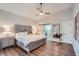 Stylish bedroom featuring a decorative ceiling fan, wood flooring, and ensuite bathroom access via sliding barn door at 11367 Perico Isle Cir, Bradenton, FL 34209
