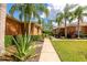 A sidewalk runs between well-maintained lawns and mature landscaping in a backyard at 11455 52Nd E Ct, Parrish, FL 34219