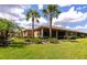 Backyard featuring a lush lawn, palm trees, and screened patio at 11455 52Nd E Ct, Parrish, FL 34219