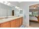 Bright bathroom featuring double sinks, wood cabinets, and a large mirror, perfect for getting ready at 11455 52Nd E Ct, Parrish, FL 34219