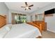Comfortable bedroom with wood furniture, ceiling fan, and sliding glass doors to patio, creating a relaxing retreat at 11455 52Nd E Ct, Parrish, FL 34219