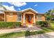 Inviting front entrance with a red door, white columns, and lush landscaping at 11455 52Nd E Ct, Parrish, FL 34219