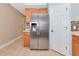 Stainless steel refrigerator with wood cabinets and tile backsplash in kitchen with tiled floors at 11455 52Nd E Ct, Parrish, FL 34219