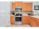 Modern kitchen with stainless steel appliances, wooden cabinetry, and a stylish tile backsplash at 11455 52Nd E Ct, Parrish, FL 34219