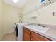 Bright laundry room with washer and dryer, storage shelves, and tile flooring at 11455 52Nd E Ct, Parrish, FL 34219