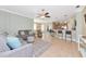 Open-concept living room leading to a kitchen bar, complete with tile flooring and comfortable seating arrangements at 11455 52Nd E Ct, Parrish, FL 34219
