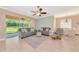 Bright living room with comfortable seating, tile flooring, and a view of the landscaped backyard through sliding doors at 11455 52Nd E Ct, Parrish, FL 34219