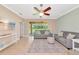 Relaxing living room with neutral tones, tile floors, a ceiling fan, and sliding glass doors to the backyard at 11455 52Nd E Ct, Parrish, FL 34219